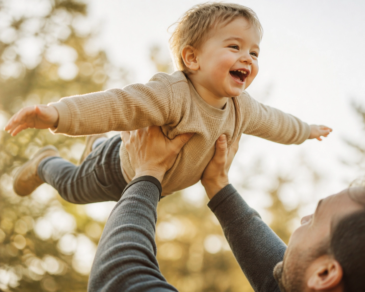 Parent lifting a child outdoors, illustrating pain-free mobility and the goal of sciatica relief for active family play.
